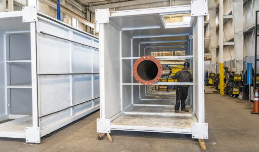 worker measuring plenum exhaust Acoustical Sheetmetal Company