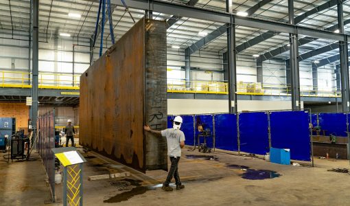 fuel tank being moved by crane in manufacturing facility Acoustical Sheetmetal Company