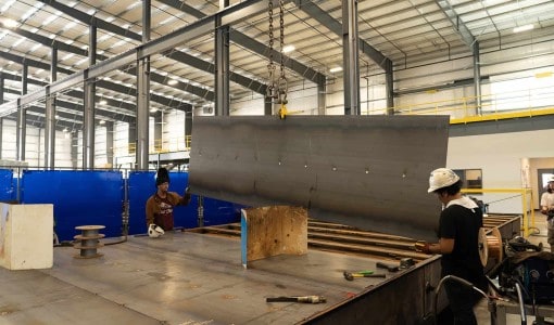 workers aligning metal plates in Hudome Way Acoustical Sheetmetal Company