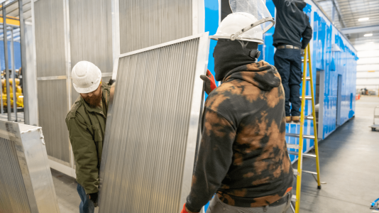 workers assembling vents for enclosure Acoustical Sheetmetal Company