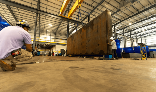 tank being lifted by crane in manufacturing facility Acoustical Sheetmetal Company